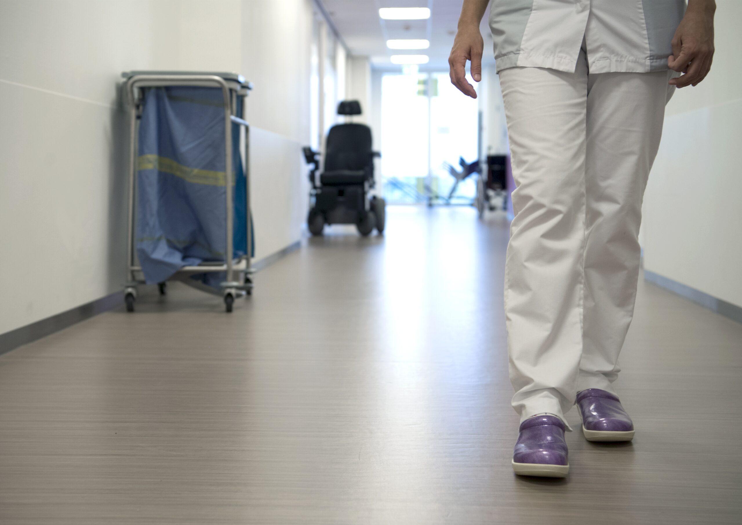 Een verpleegkundige loopt over de gang van een verpleegafdeling (foto: Frank Muller / HH).